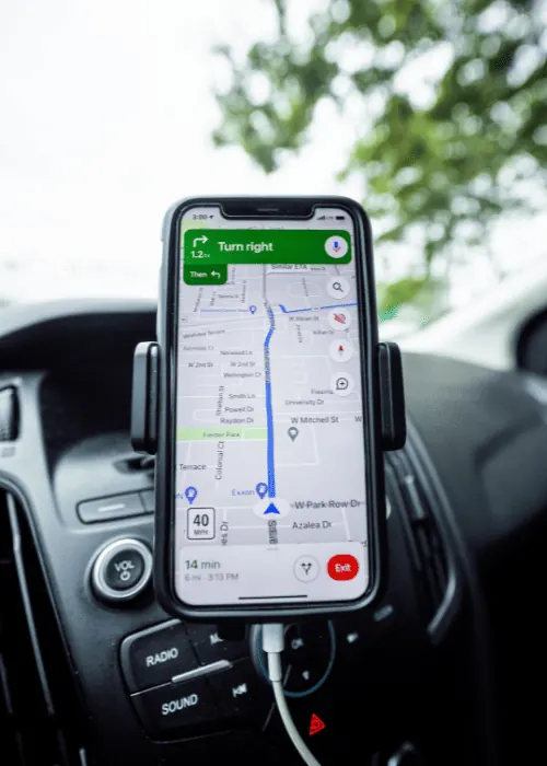 Teléfono móvil mostrando una ruta en Google Maps dentro de un vehículo
