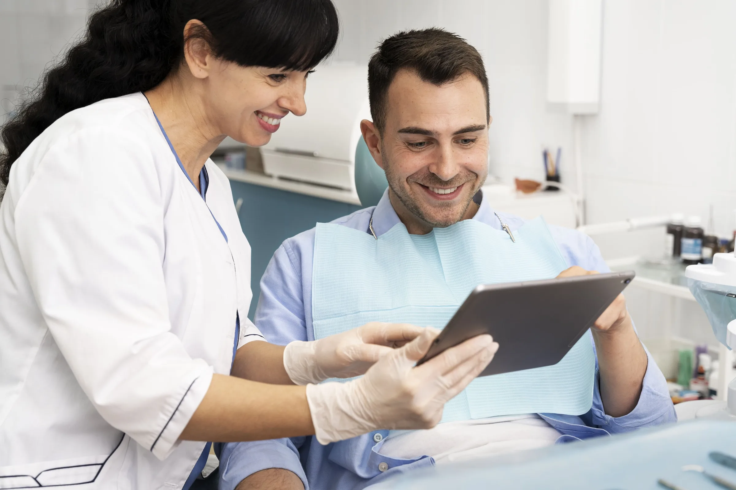 Dentista mostrando información en una tableta a un paciente