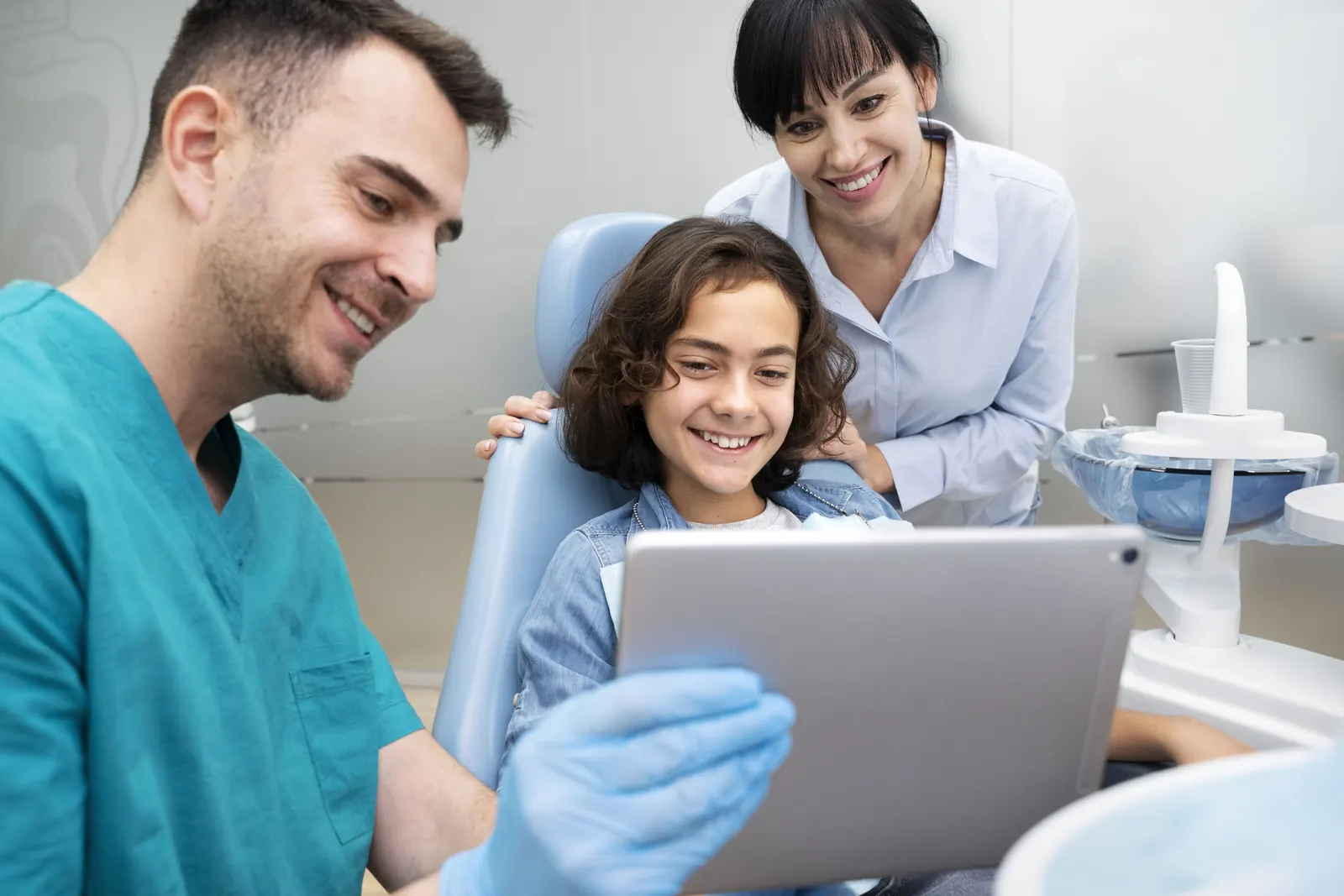 Dentistas mostrando información a un niño durante una consulta