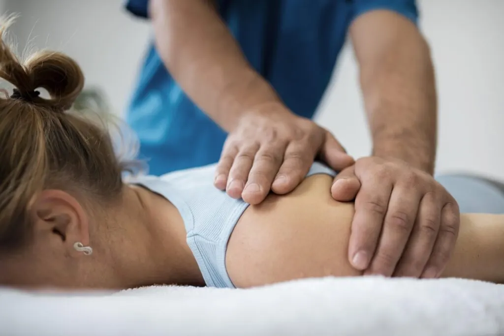 Fisioterapeuta realizando un tratamiento manual en la espalda de una paciente