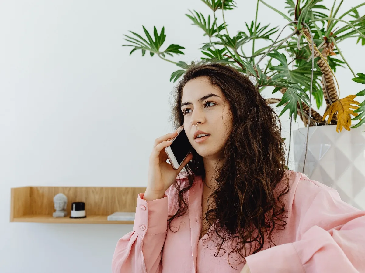 Mujer hablando por el móvil en casa para pedir información o cita